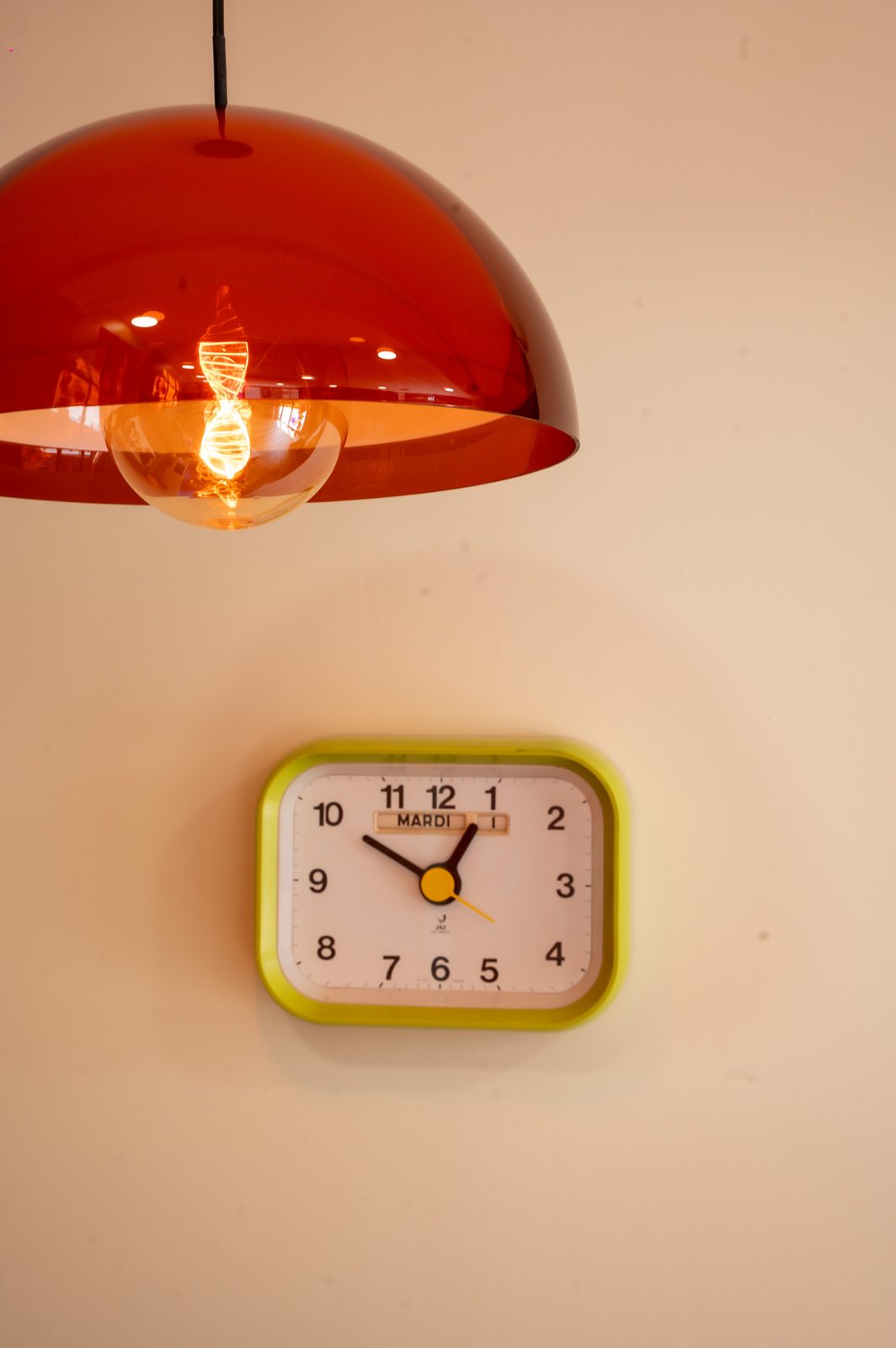 Suspension orange et horloge rétro — ambiance seventies Anna Marini